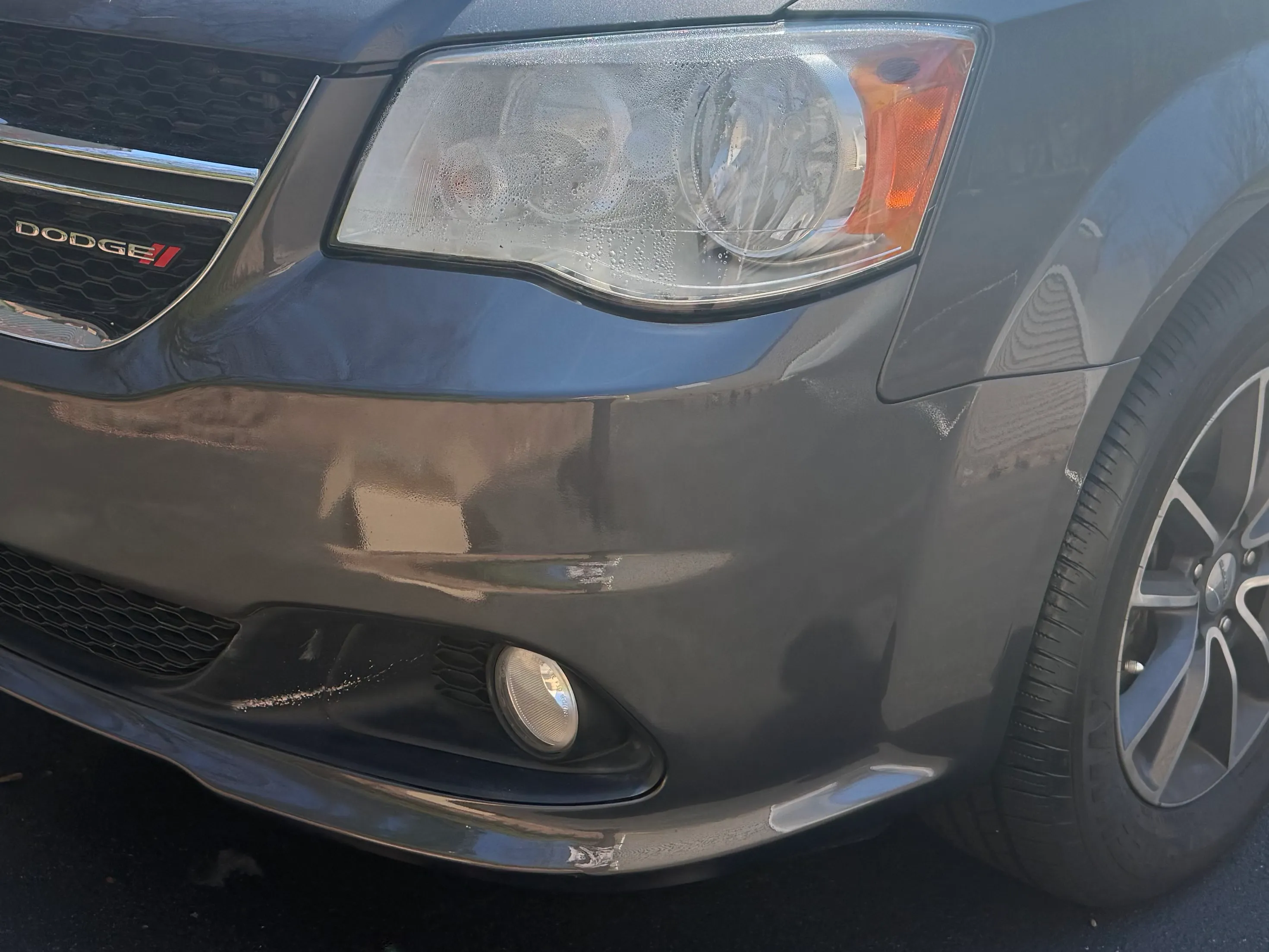 Same Dodge Grand Caravan front bumper after repair, smooth and color matched.