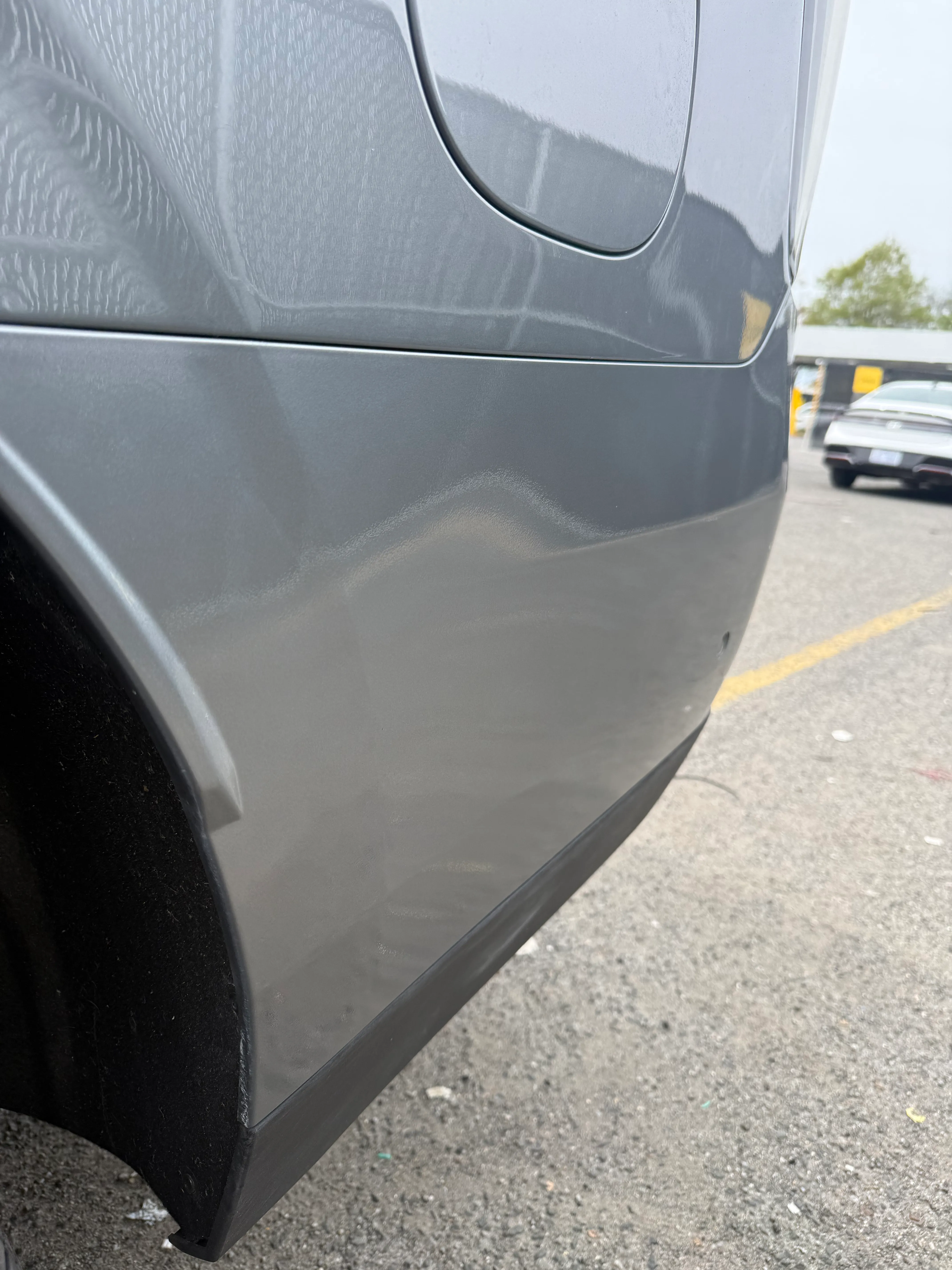 Same Chevrolet Suburban rear quarter panel after repair, smooth and color matched.